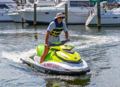 person riding a green jet ski in a marina in Gulf Shores, Alabama