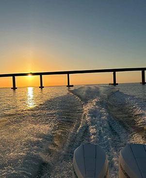 Sun setting over calm Gulf waters during a scenic sunset cruise along Floridas 30A coastline