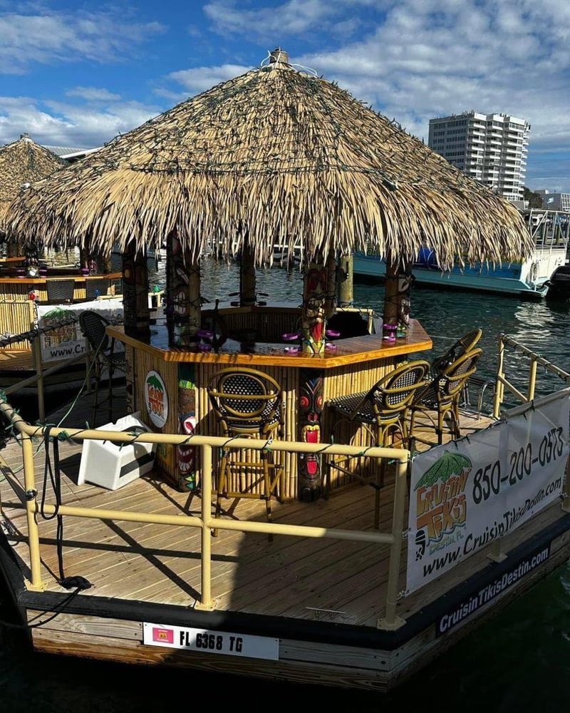 Bamboo tiki boat with bar seating docked in Destin Harbor.