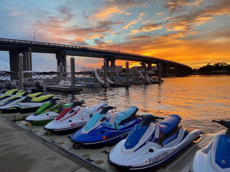 Jet skis lined up at marina near Brooks Bridge at sunset in Fort Walton Beach