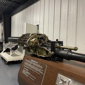 Closeup of military gun and weapon system exhibit inside museum with informational plaque