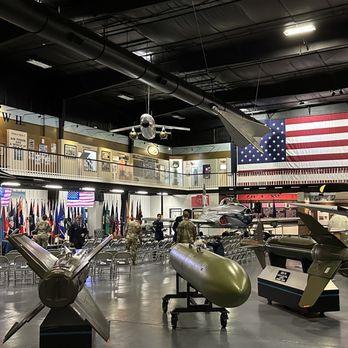 Interior museum display featuring bombs and missiles with American flag and military artifacts
