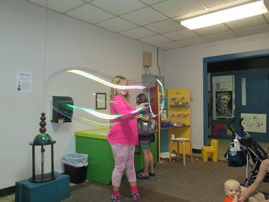 Child creating light trails during handson science exhibit at Emerald Coast Science Center