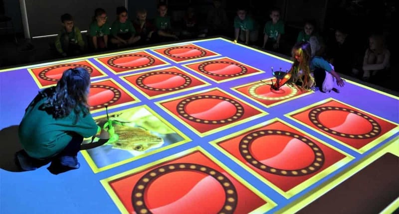 Children playing interactive digital science game table at Emerald Coast Science Center