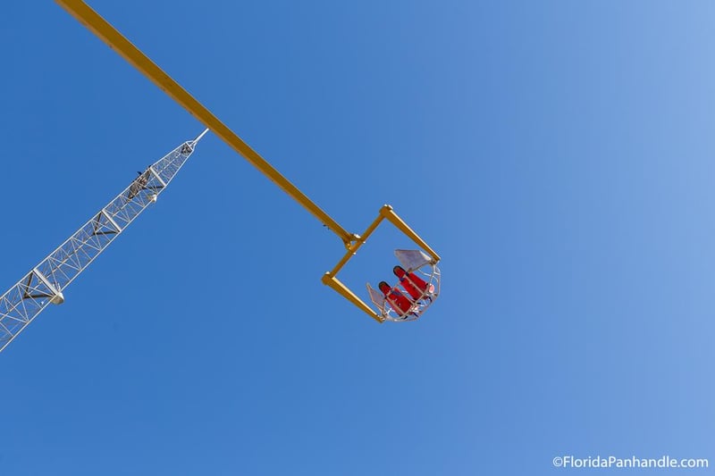 Riders lifted high above Cobra Adventure Park on thrill ride in Panama City Beach