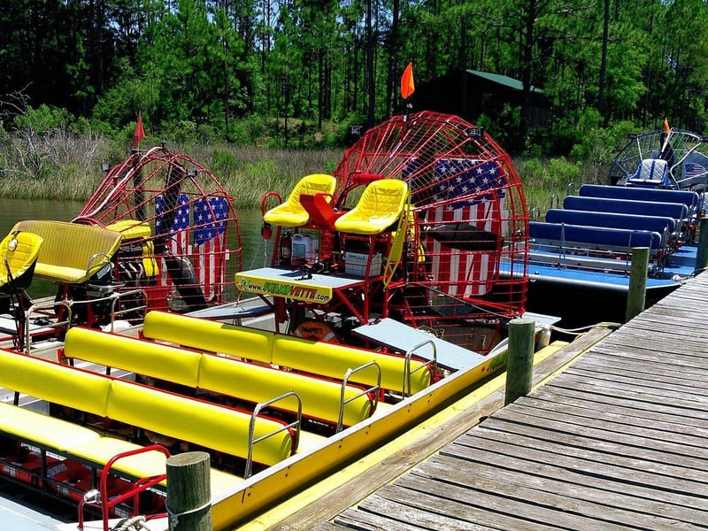 Airboats docked along wooden pier at Airboat Adventures in Panama City Beach