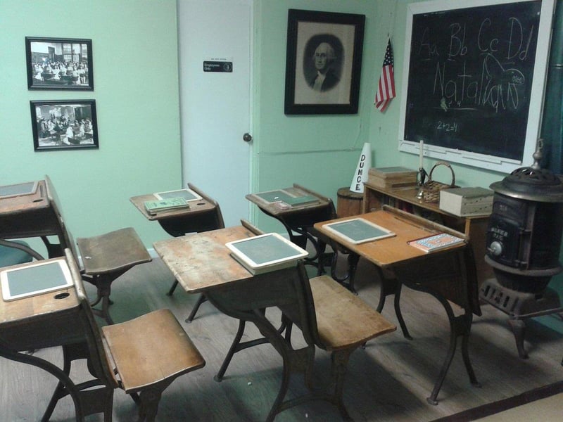 Historic classroom exhibit with wooden desks and chalkboard at Heritage Museum of Northwest Florida