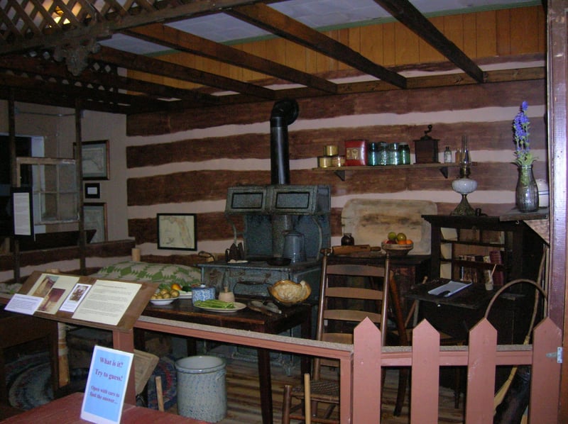 Pioneerera cabin interior exhibit with wood stove and furnishings at Heritage Museum in Fort Walton Beach