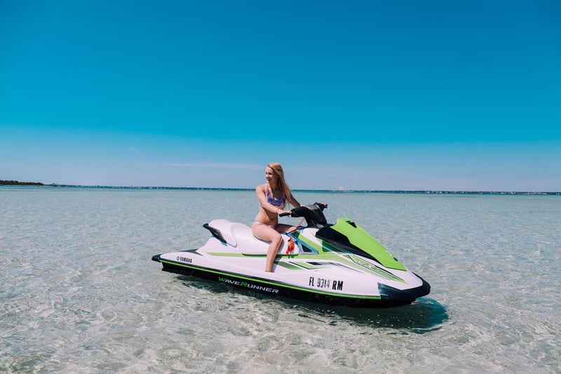 Woman riding jet ski in shallow clear water near Crab Island in Fort Walton Beach