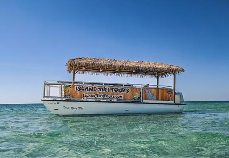Island Tiki Tours boat floating in clear Gulf waters