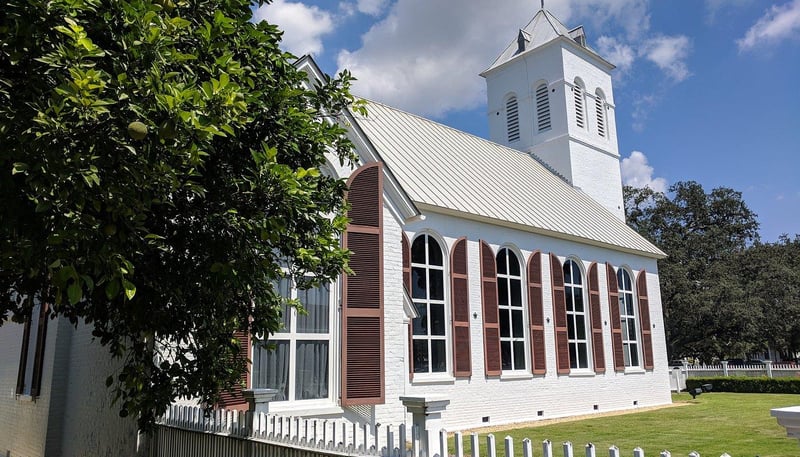 Historic church building with white exterior and tall windows in Pensacola