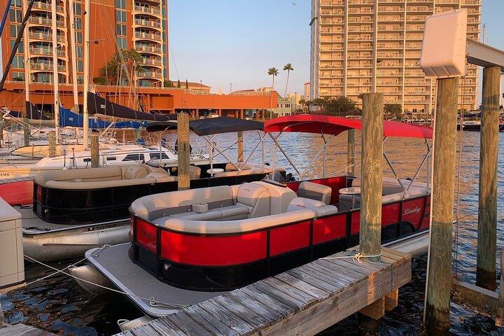 Pontoon boats docked at marina in Pensacola Beach at sunset