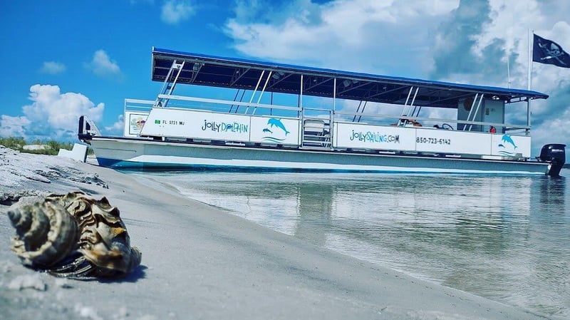 Jolly Sailing boat anchored along sandy shoreline in Pensacola Beach