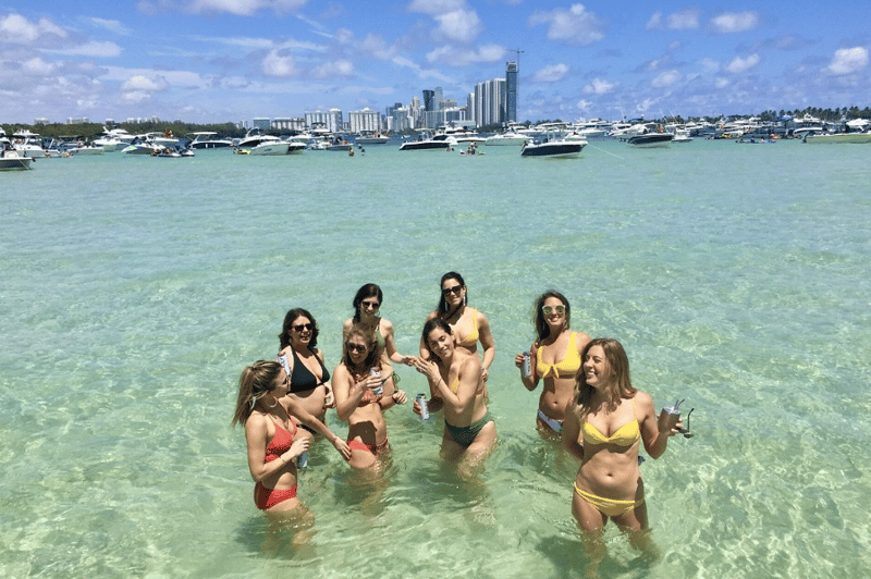 Guests relaxing on a sunny Siesta Key sandbar with crystalclear water