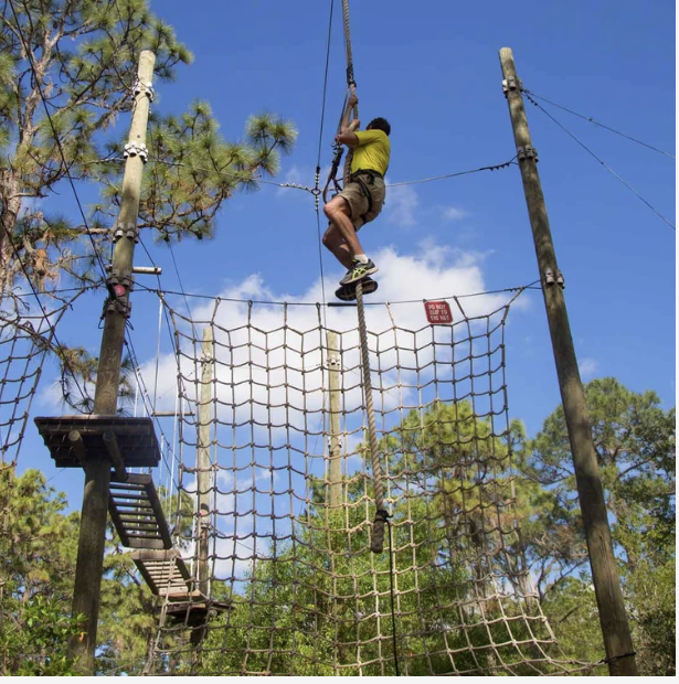 Guests zip lining through a dense Florida forest canopy