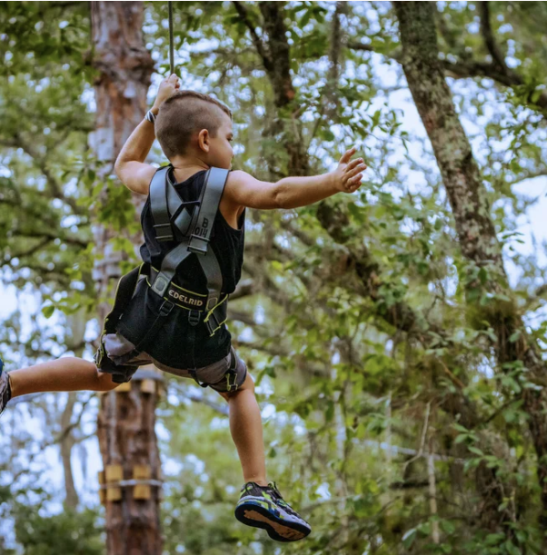 Closeup of climbers tackling rope swings and hanging obstacles
