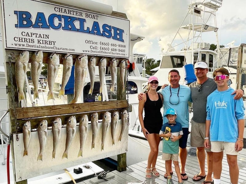 A group at the dock in Destin, Florida with their catch from a fishing trip on Backlash