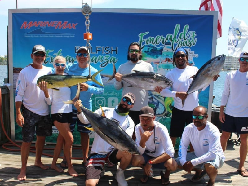 A group with a variety of fish in front of Big Johns sign in Destin, Florida