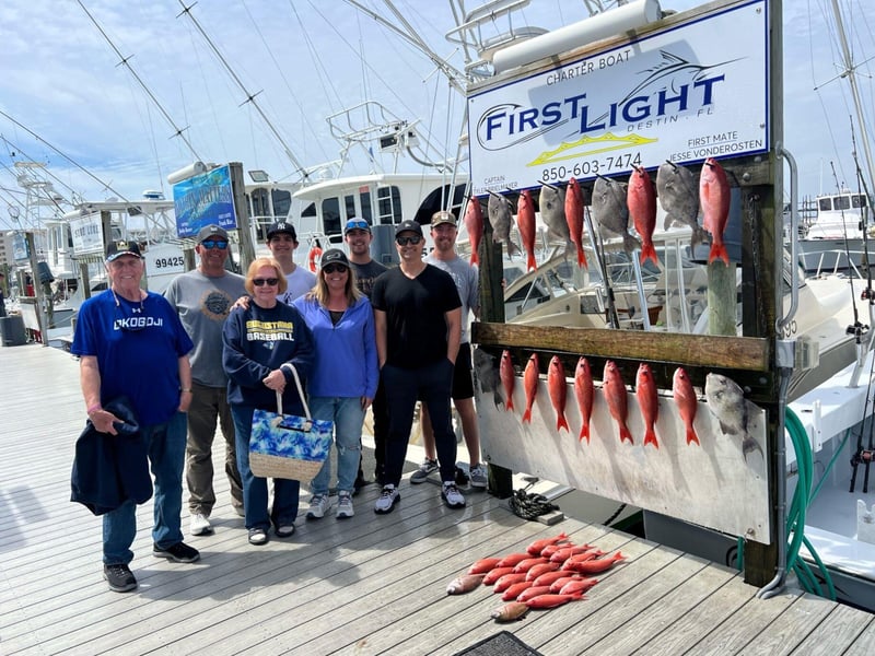 A group standing in front of First Lights sign on the dock