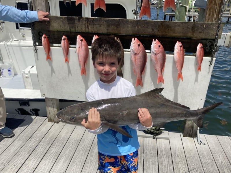 A young kid with his catch on the dock in Destin, Florida