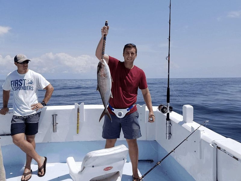 A man holding a fish on board Miss Nautica in Destin, Florida