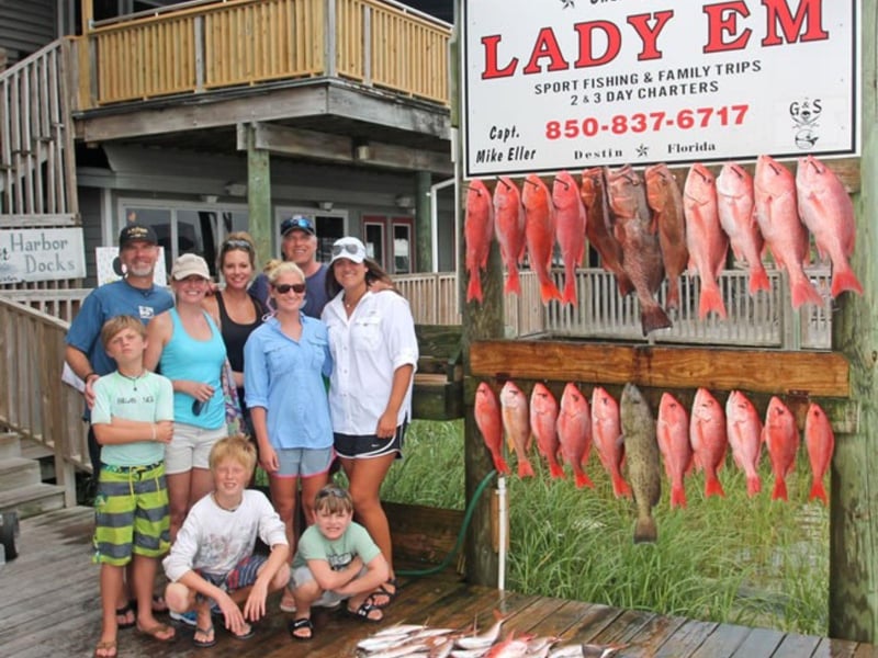 A family on the dock with their catches from Lady Em in Destin, Florida