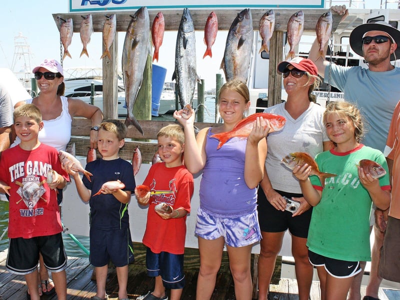 A family on the dock with their catch from Silver Lining in Destin, Florida