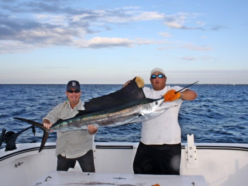 Two men holding their giant catch on board Silver Lining