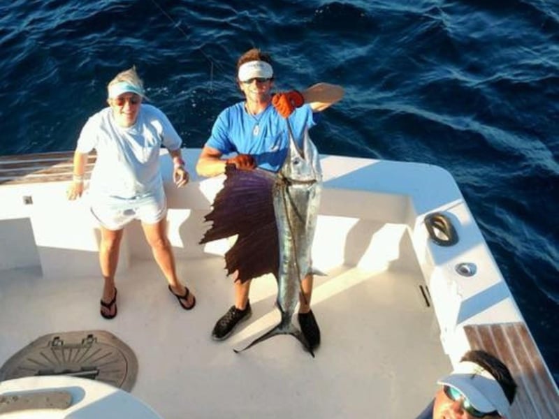 Two men showing off their catch on board Sunrise