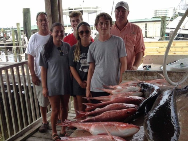 A family on the dock with their catch from Summer Hunter in Orange Beach, Alabama