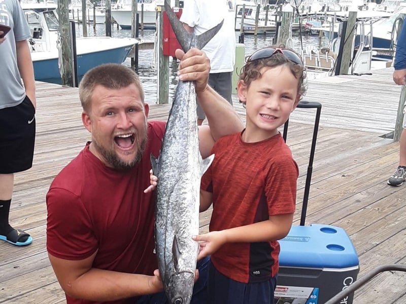 A father and son holding their catch on the dock in Orange Beach, Alabama