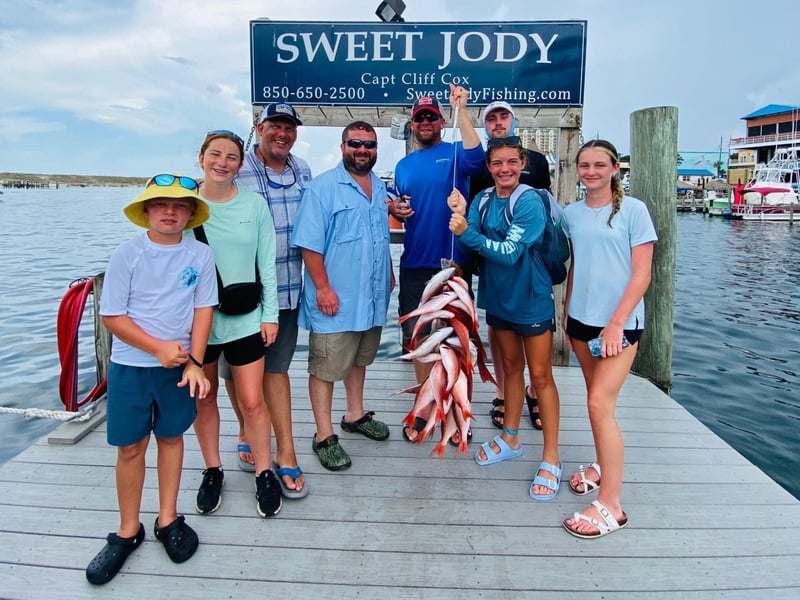 A group on the dock with their catches from Sweet Jody in Destin, Florida