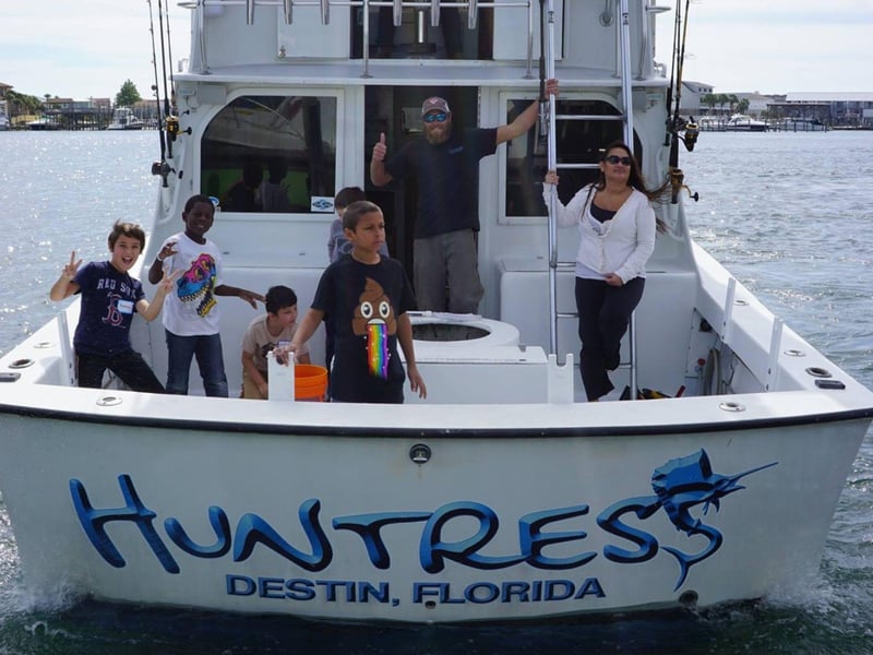 A family on the back of the Huntress on the water off the coast of Destin, Florida
