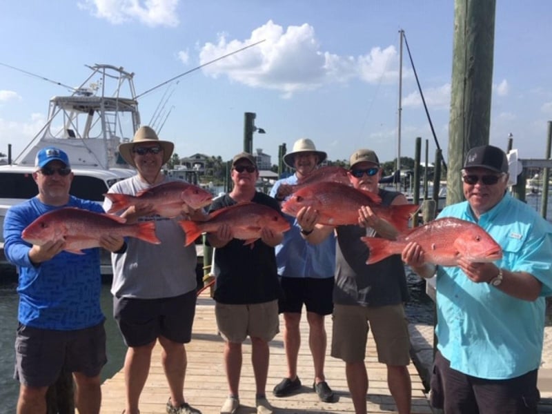 A group showing off their catches from Sure Shot on the dock