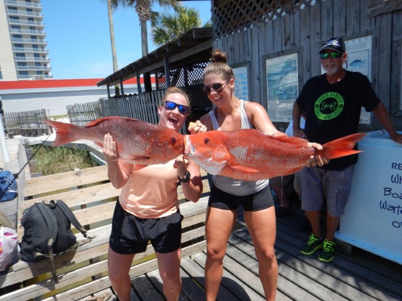 A group on the dock with their catch from Reel Eazy in Pensacola Beach, Florida