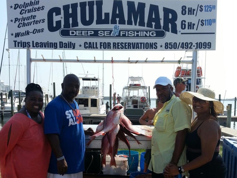 A group showing off their catch on the dock in Pensacola Beach, Florida