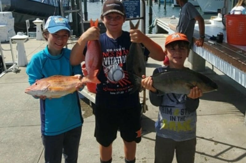 A group showing off their catch on the dock in Pensacola Beach, Florida