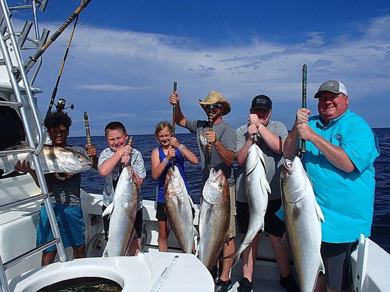 A group showing off their catches from a fishing charter