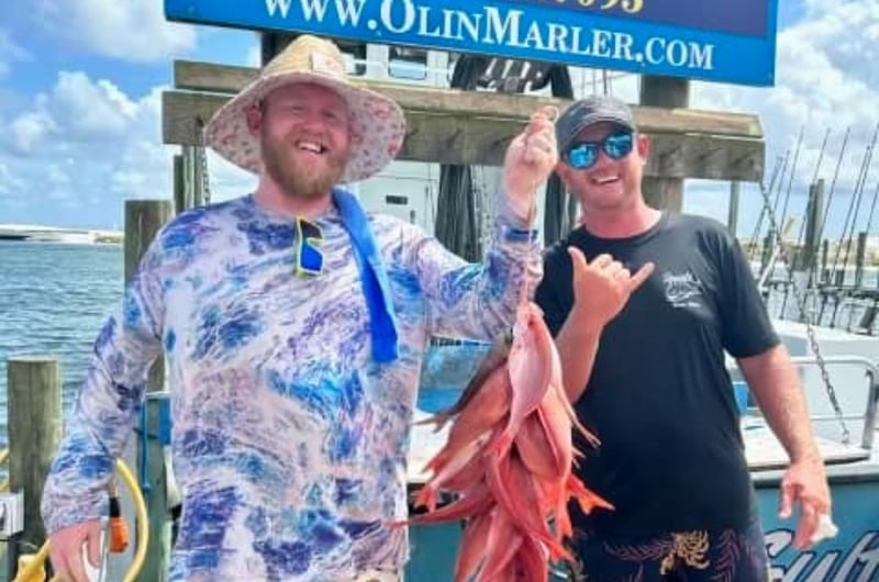 Two men showing off their catch from a fishing trip with Olin Marler in Destin, Florida