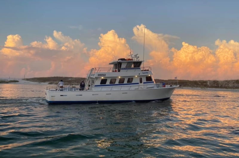One of the Olin Marler Charter Fishing Service fishing boats on the water at sunset