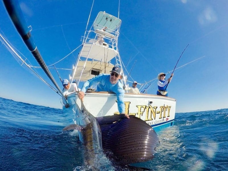A man fishing off the side of a boat in Sarasota, Florida