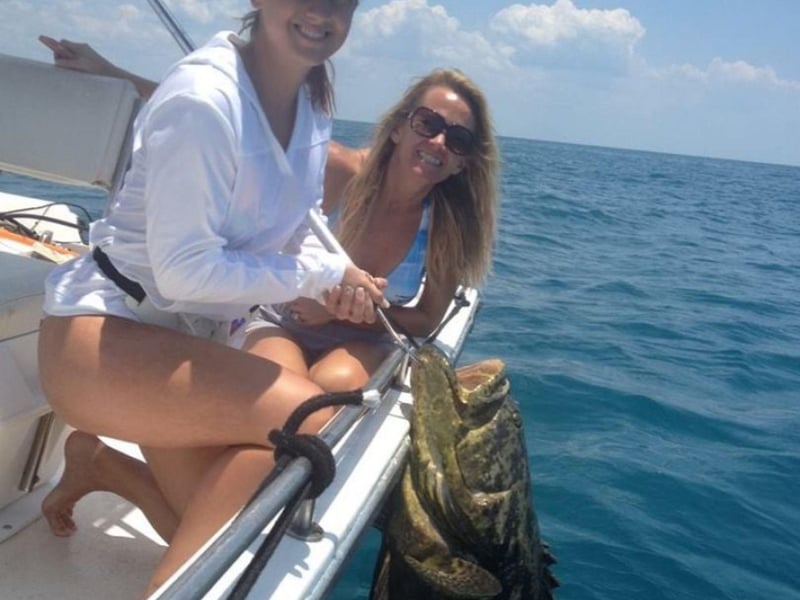 Two women fishing off the side of a boat in Sarasota, Florida