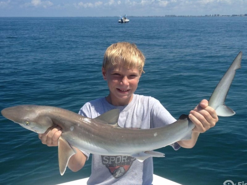 A young boy showing off his catch on the boat with Rodbender Fishing Charters