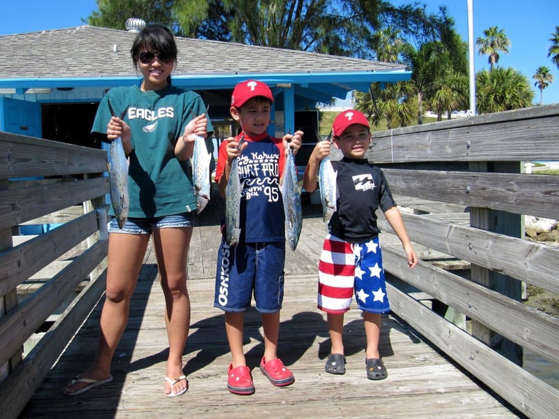 A family showing off their catch on the dock in Sarasota, Florida