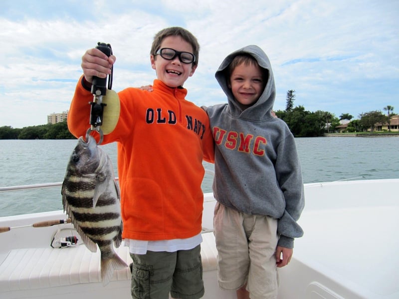 Two boys with their catch on the back of the boat