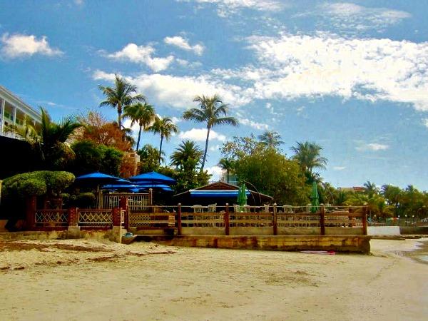 palmshaded wooden deck behind Louies Backyard restaurant in Key West