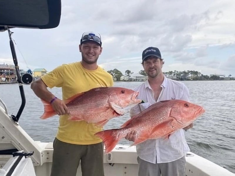 Two men showing off their catch on Alibi 2 in Orange Beach, Alabama