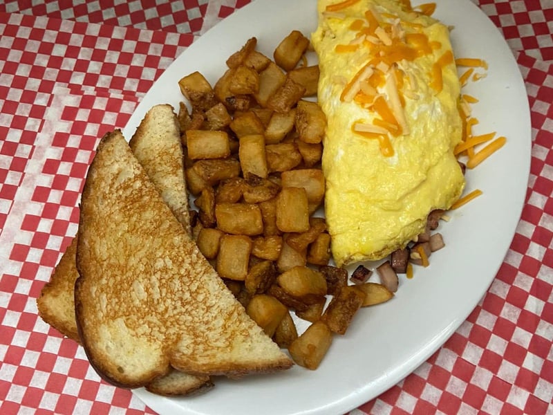 A ham and cheese omlette with potatoes
