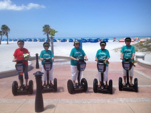 Five women pose at the end of a Gulffront path at Clearwater Beach on Segways from The Segway Adventure.