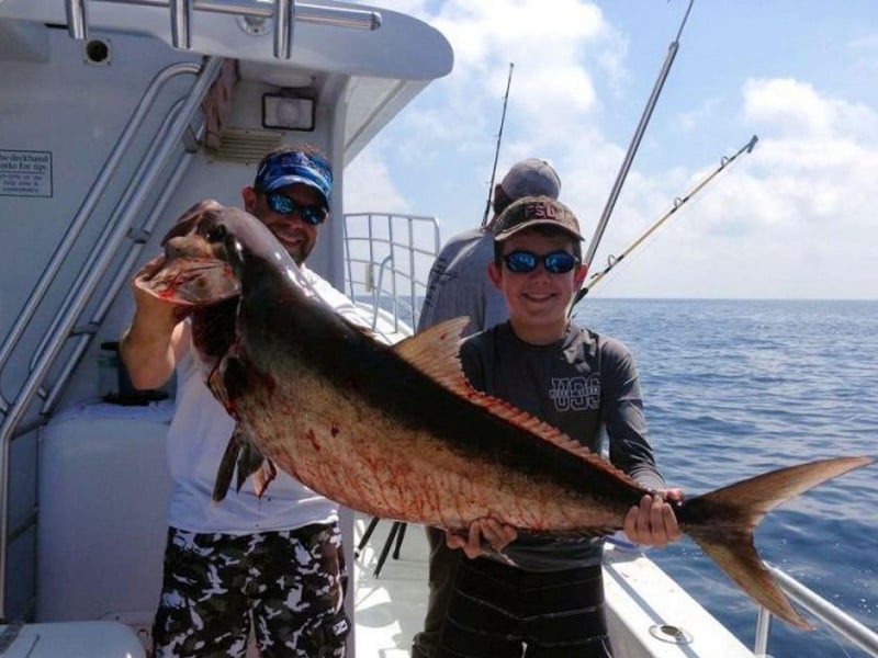A group showing off their catch on board Total Package Charters